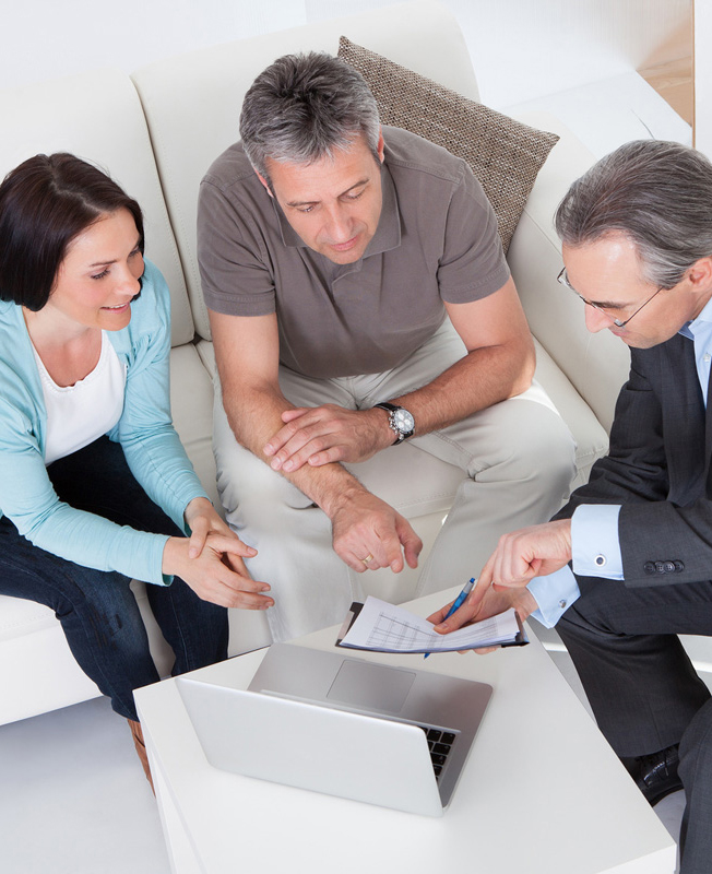 Happy Couple And Mature Consultant Discussing Together